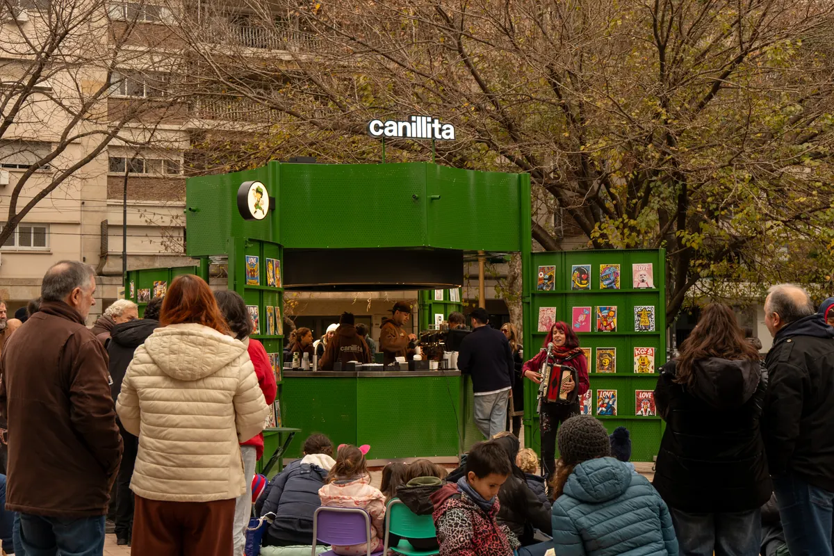 Público frente a un puesto Canillita durante un show